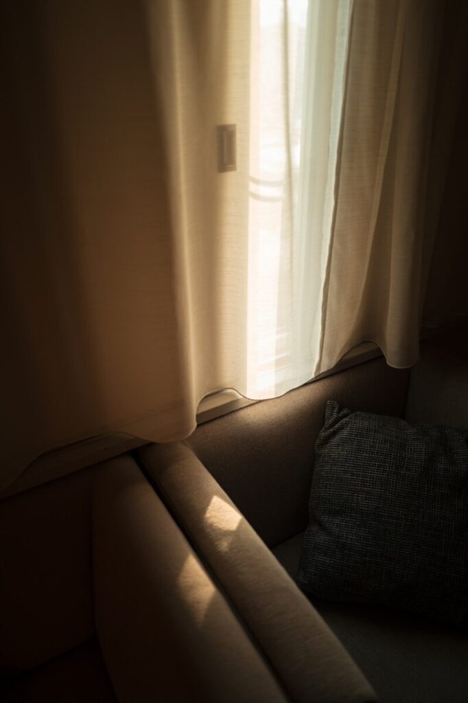 Sunlight streams through a window onto a sofa.